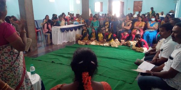 Community gathering with children and adults indoors.