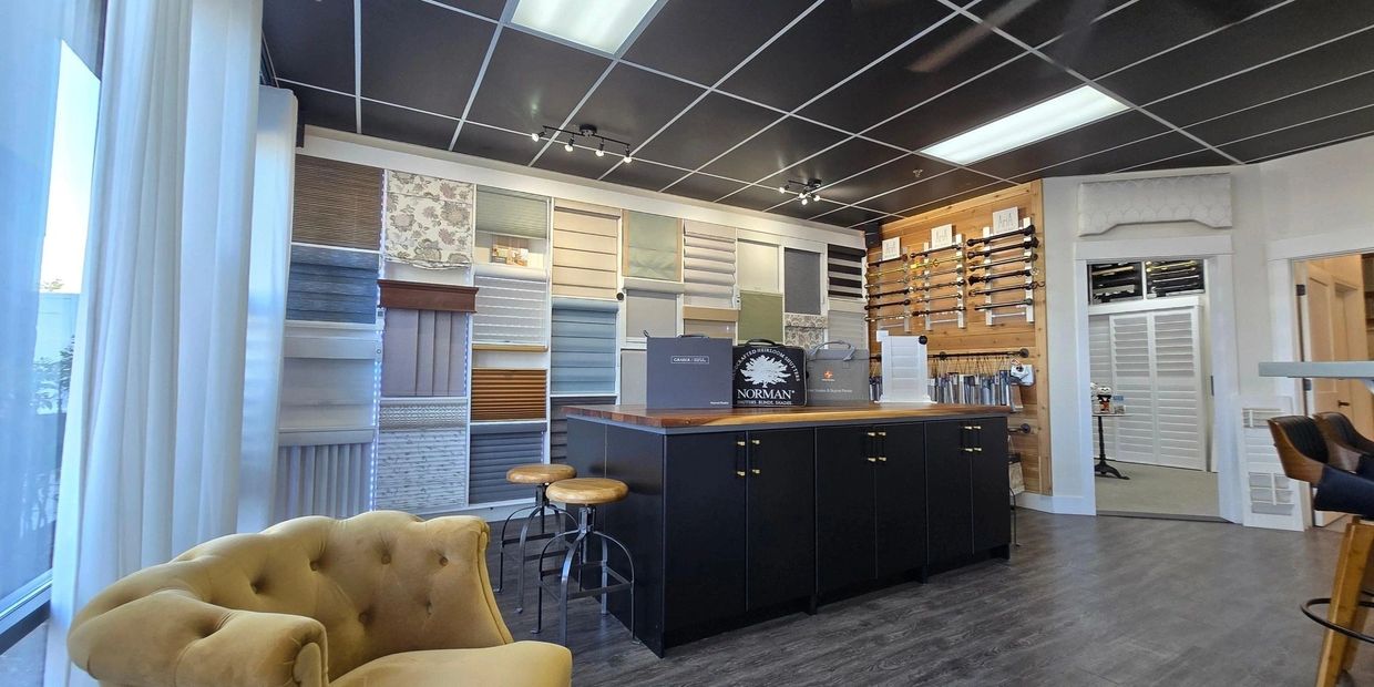 Modern showroom with window blind samples and seating area.