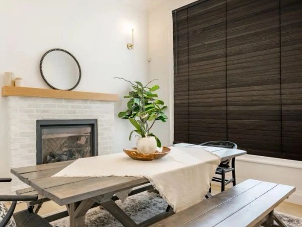Cozy dining table with a plant centerpiece and fireplace.