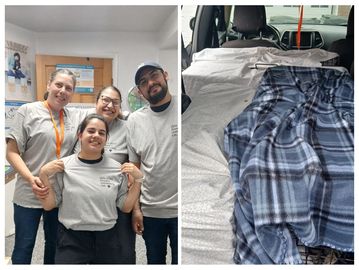 Four people in matching shirts smile together indoors.