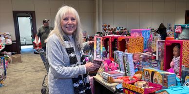 Smiling woman helping with toy organization