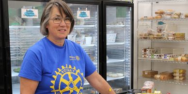 woman helping stock shelves in community food pantry
