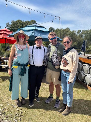 four people standing and smiling