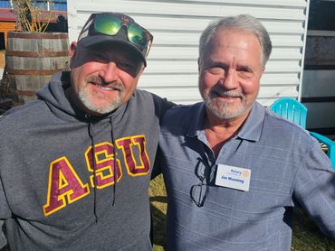 Two men smiling with arms arond each other's shoulders