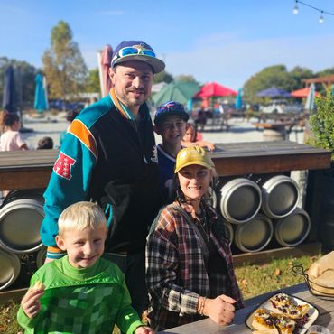Family of four smiling and eating food in outdoor courtyard