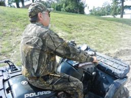 A hunter sitting on a quad while wearing a Hip Stick Shooting Rest on his hip heading out to hunt
