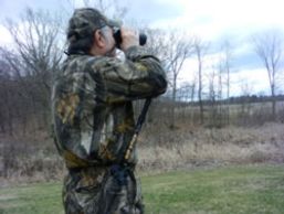 A Hunter using a Hip Stick Shooting Rest on his hip to steady his Binoculars while hunting