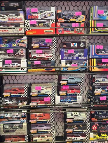A display case filled with boxed collectible NASCAR die-cast cars and memorabilia.