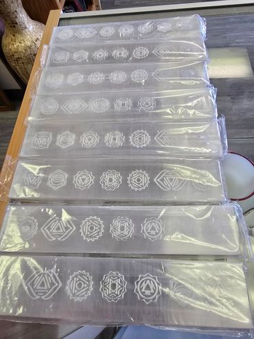 Engraved clear crystal slabs with intricate geometric patterns on a wooden table.