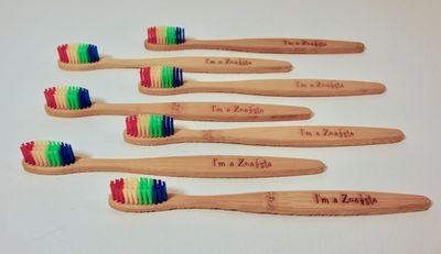 Coral Engraved Bamboo Toothbrushes with rainbow bristles.