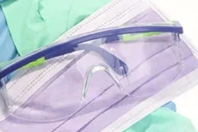 Clear safety goggles on a purple medical surface.