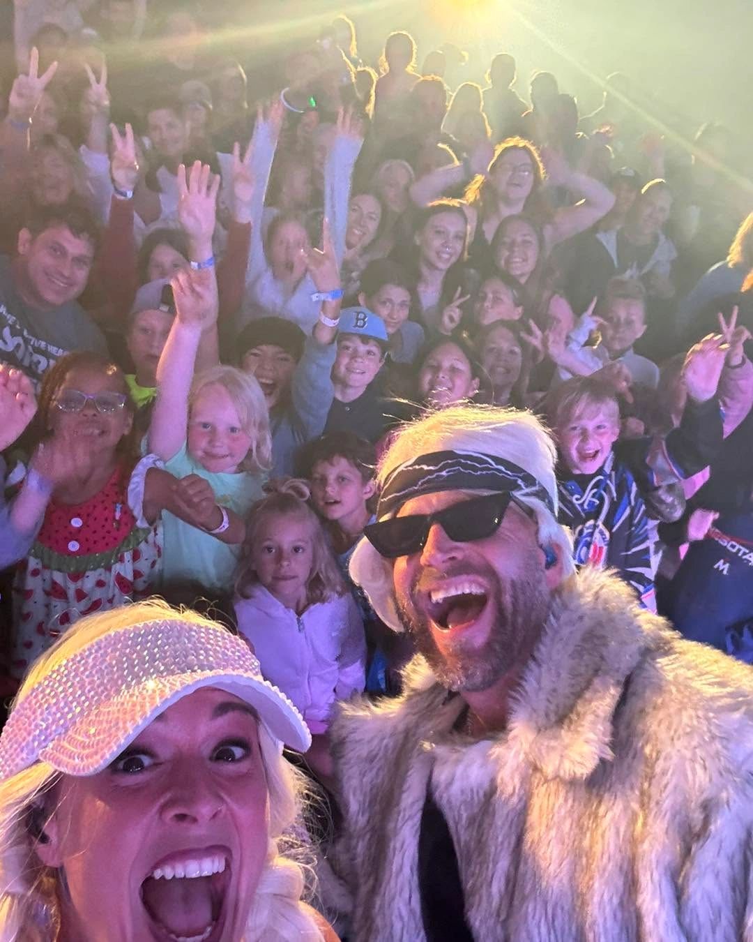Crowd selfie with excitement and smiles.