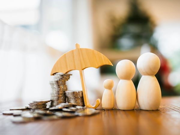 Wooden family figures with umbrella and coins.