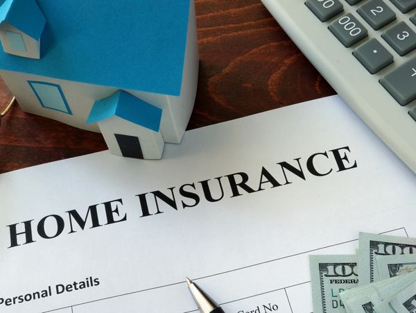 Home insurance form with model house and money.