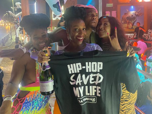 Friends celebrating with a hip-hop themed shirt and champagne in a lively venue.