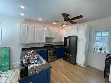 Modern kitchen with blue lower cabinets and white upper cabinets.