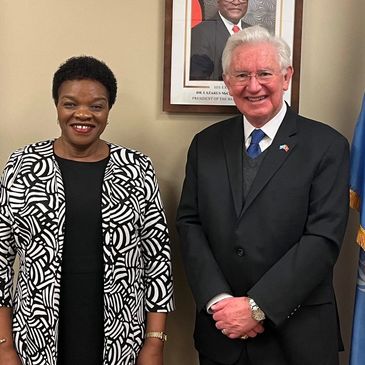 Two well-dressed individuals posing indoors.