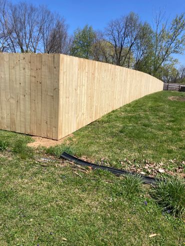 Newly installed wooden privacy fence on a sunny day.