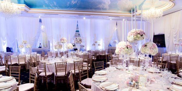 Elegant wedding reception hall with floral centerpieces and chandeliers.