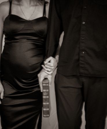 Couple holding hands, one holding a Bible.