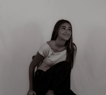 Smiling young woman looking up thoughtfully.