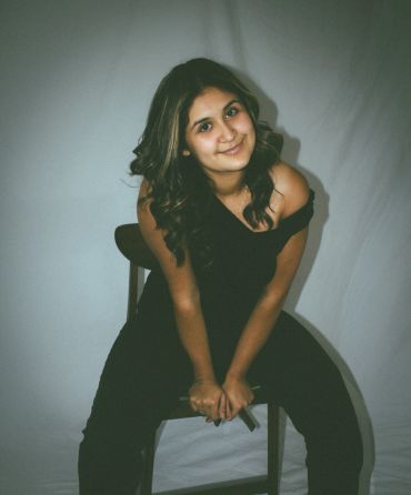 Young woman sitting on a chair, smiling.