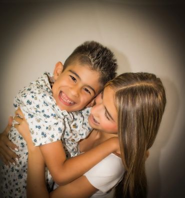 A joyful boy and woman embrace warmly.