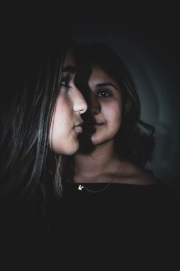 Two faces with dramatic lighting and shadows.