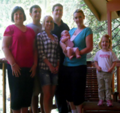 A multi-generational family, including a baby and a small child, posing for a group photo