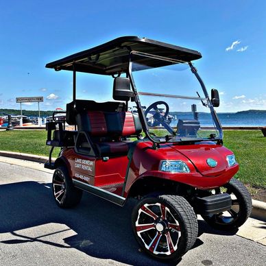 red evolution golf cart in front of lake Geneva