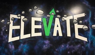 Graffiti art of the word ELEVATE with a green arrow on the V.