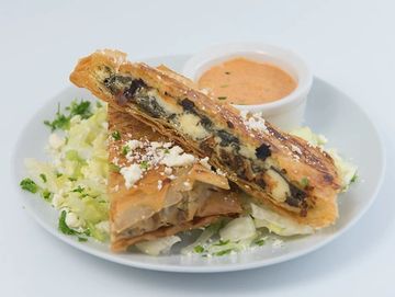 Spanakopita over lettuce and side sauce.