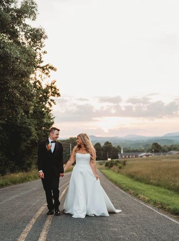 all-inclusive NC wedding venue featuring just married couple walking on the road at sunset.