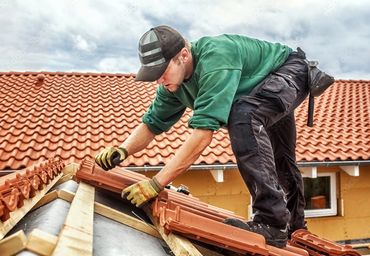 Man on roof replacing shingles.