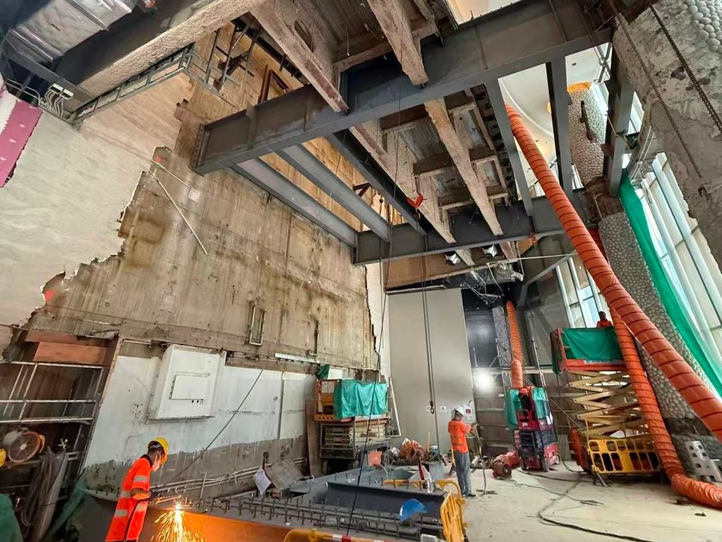 建筑工地内工人焊接和施工场景。
