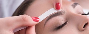 Woman getting eyebrow waxing.