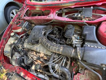 Engine bay of a red car with visible 2200 SEi engine components.