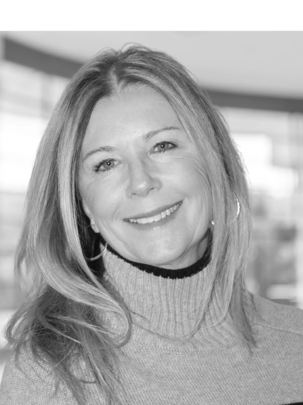 Smiling woman with long hair wearing a turtleneck sweater.