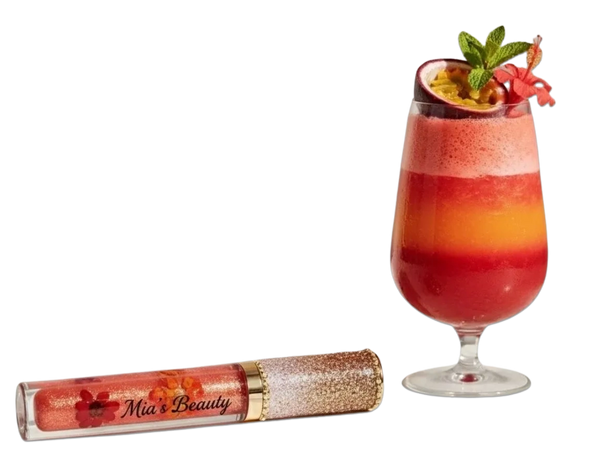 A glittery lip gloss tube next to a vibrant layered fruit drink with garnish.