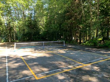 A sports court with pickleball markings and equipment is available for all guests.