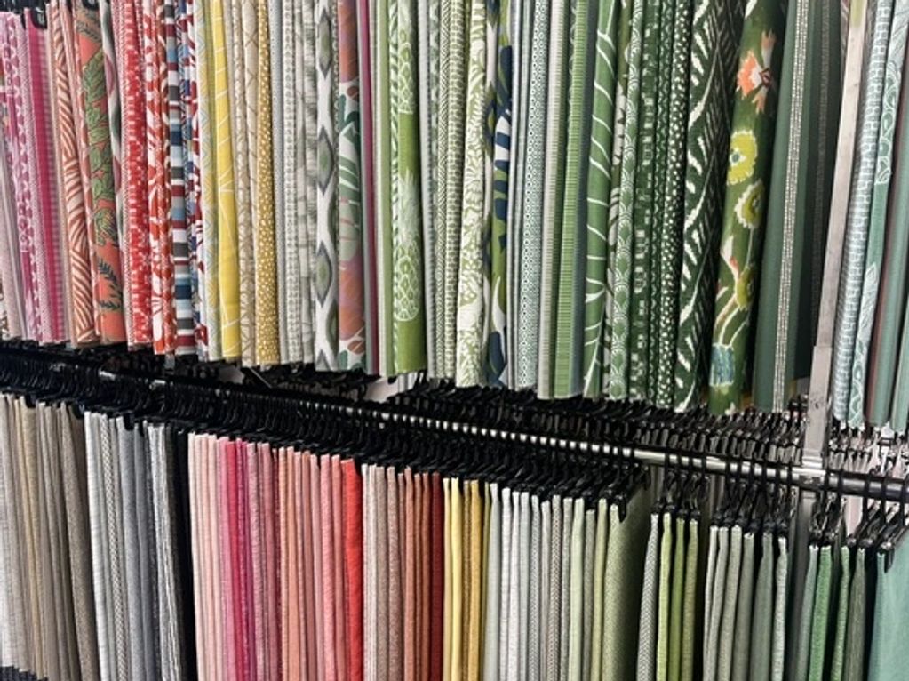 Rows of colorful fabric hanging on racks.