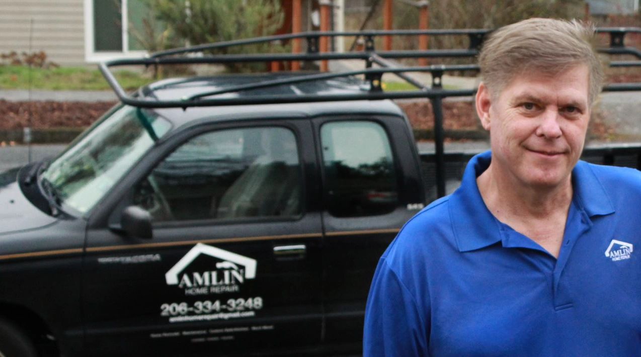 Mark Amlin, owner of Amlin Home Repair, posing in front of his work truck with the business logo
