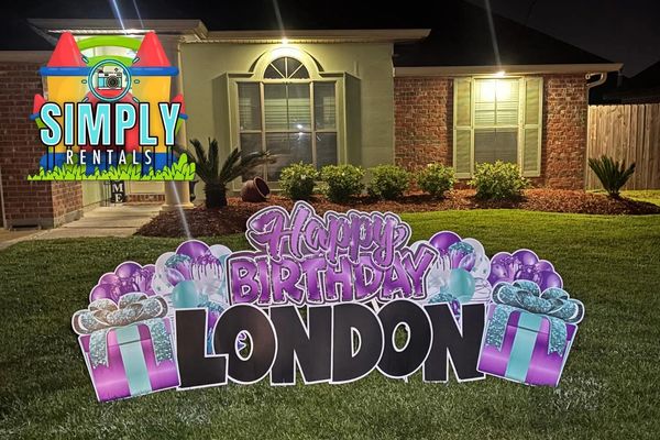 Birthday yard sign saying "Happy Birthday London" at night.
