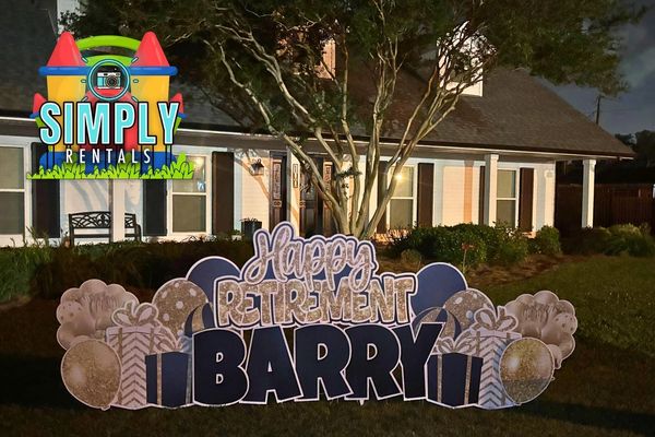 Outdoor lawn sign celebrating Barry's retirement at night.