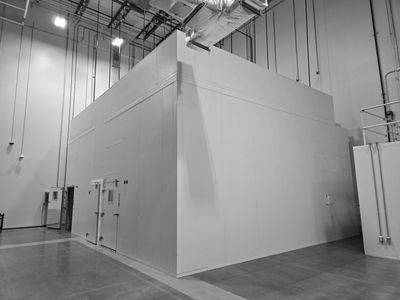 Large industrial white room inside a warehouse with high ceilings.