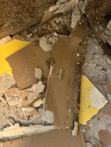 Broken and dirty pieces of drywall and plaster on the floor.