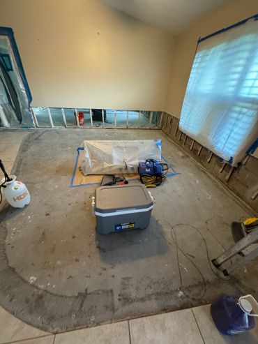 Room under water damage restoration with exposed walls and equipment.