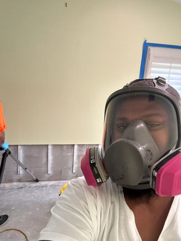 Person wearing a respirator mask during indoor cleanup or renovation.