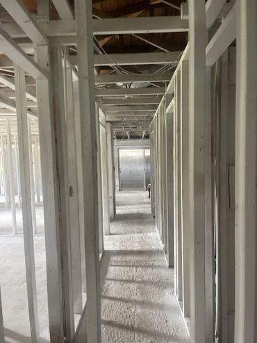 Interior framework of a building under construction with exposed wooden beams and studs.