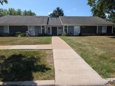 Single-story house with a concrete walkway and lawn.